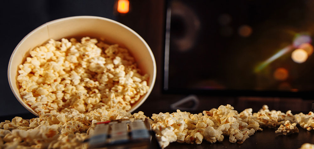 Popcorn scattered beside a remote